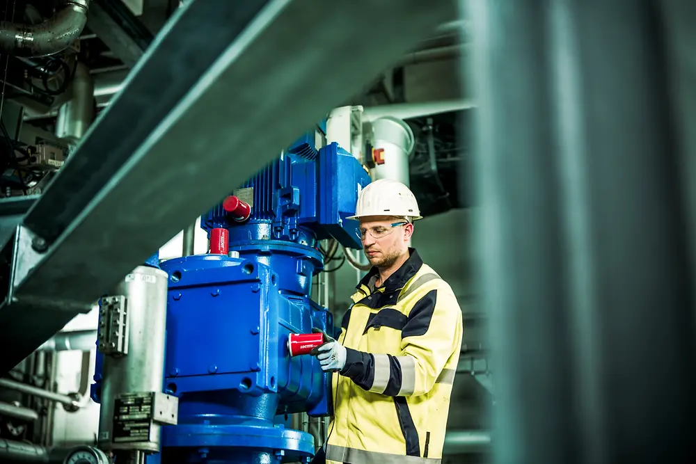 Person checks Loctite Pulse Rotating Equipment in a motor at the Henkel plant in Düsseldorf